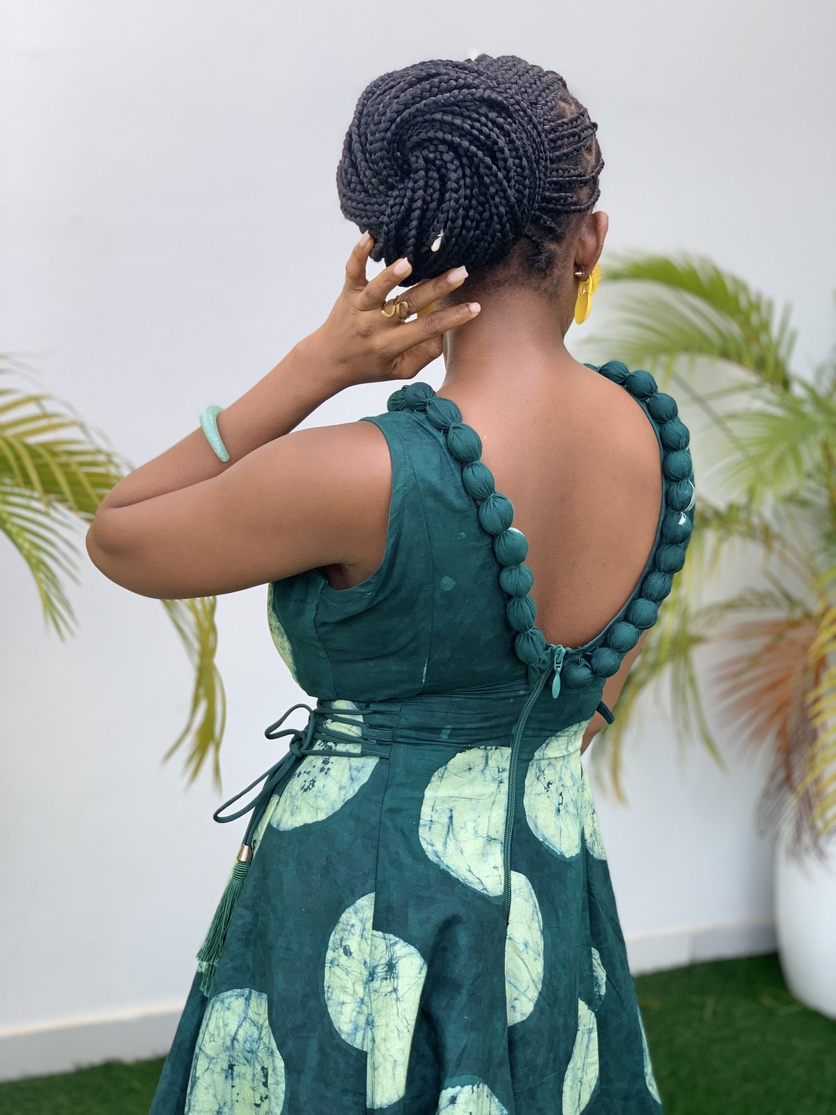 AFẸ́FẸ́ I, the pom-pom trim framing the open back